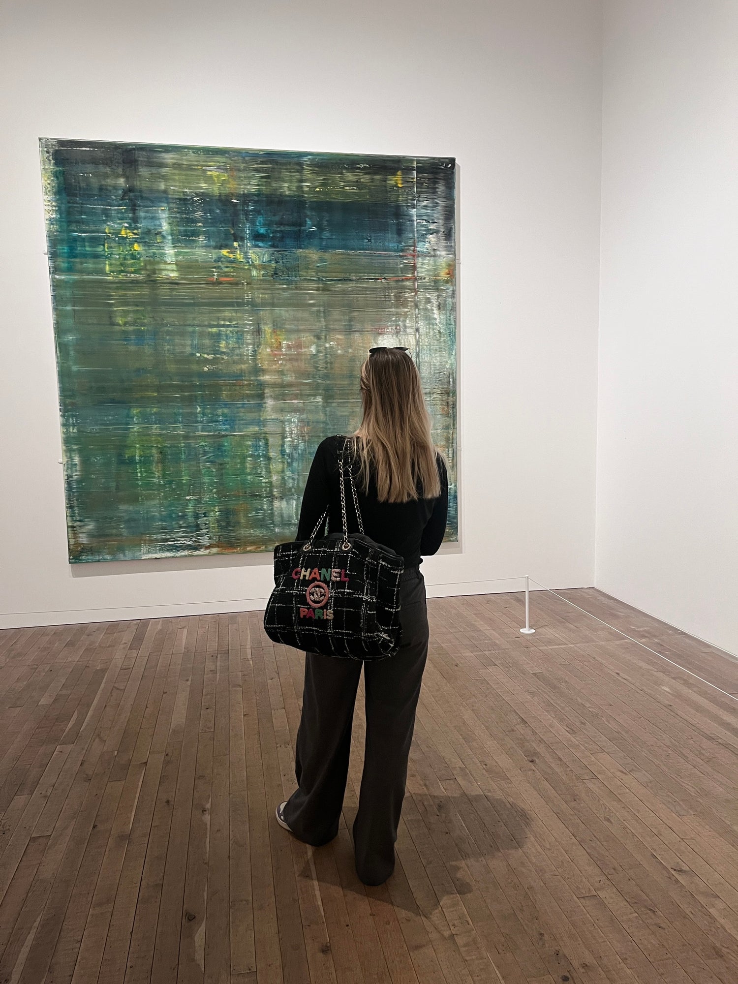 Bild av en besökare på tate modern museum i london som tittar på en stor grön abstrakt tavla av konstnären gerhard richter