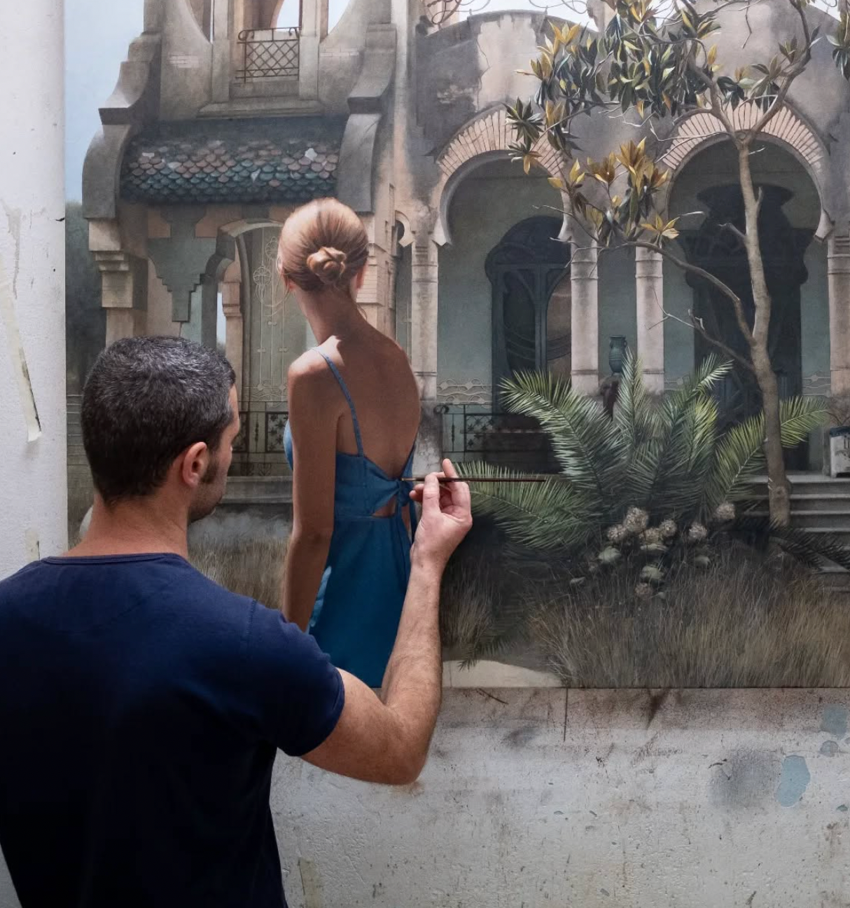 Figurativa konstnären Marc Figueras från Barcelona i process att skapa ett verk som föreställer en ung kvinna framför ett äldre hus med pelare och en trädård